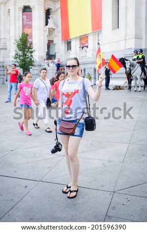 MADRID, SPAIN - JUN 19, 2014: Unidentified Spanish girl waves the Spanish national flag in the centre of Madrid during the celebration of the coronation of the New King of Spain Felipe IV