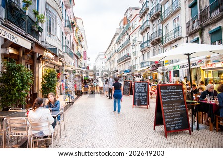 LISBON, PORTUGAL - JUN 20, 2014: Unidentified tourists walk and eat in the touristic area in Lisbon, Portugal. Lisbon is  the seventh-most-visited city in Southern Europe