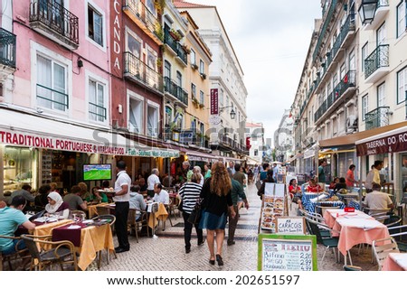 LISBON, PORTUGAL - JUN 20, 2014: Unidentified tourists walk and eat in the touristic area in Lisbon, Portugal. Lisbon is the seventh-most-visited city in Southern Europe