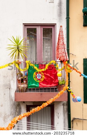 PORTO, PORTUGAL - JUN 21, 2014:  Balcony with the national flag in Porto, Portugal. Porto is the second largest city in Portugal and it was called the European Culture Capital in 2001