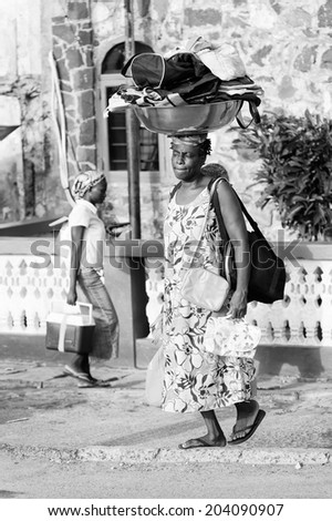 ACCARA, GHANA - MAR 2, 2012: Unidentified Ghanaian woman sells bags from over her head in black and white. People of Ghana suffer of poverty due to the unstable economical situation