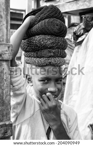 ACCARA, GHANA - MAR 3, 2012: Unidentified Ghanaian boy who sells hats in black and white. People of Ghana suffer of poverty due to the unstable economical situation
