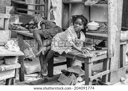 ACCARA, GHANA - MAR 4, 2012: Unidentified Ghanaian beautiful girl gets up of a bench in black and white. People of Ghana suffer of poverty due to the unstable economical situation