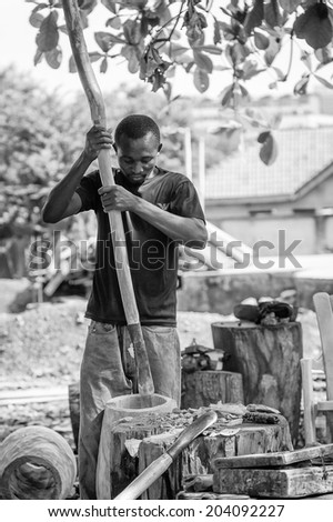 ACCARA, GHANA - MAR 3, 2012: Unidentified Ghanaian work makes wodden articles in black and white. People of Ghana suffer of poverty due to the unstable economical situation