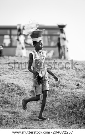 ACCARA, GHANA - MAR 2, 2012: Unidentified Ghanaian girl sells cold water in black and white. People of Ghana suffer of poverty due to the unstable economical situation
