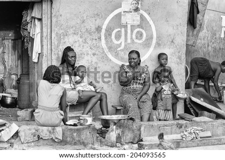 ACCARA, GHANA - MAR 2, 2012: Unidentified Ghanaian people sit and talk in the street  in black and white. People of Ghana suffer of poverty due to the unstable economical situation