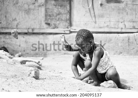 ACCARA, GHANA - MAR 2, 2012: Unidentified Ghanaian boys play in the street in the street in black and white. Children of Ghana suffer of poverty due to the unstable economical situation