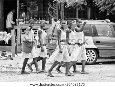 ACCARA, GHANA - MAR 2, 2012: Unidentified Ghanaian girls walk in the street in the street in black and white. People of Ghana suffer of poverty due to the unstable economical situation