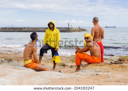 ESTORIL, PORTUGAL - JUNE 22, 2014: Unidentified men on the coast of the Atlantic ocean on The Beach of Tamariz, Estoril, Portugal. Estoril is one of the most expensive resort area in Western Portugal