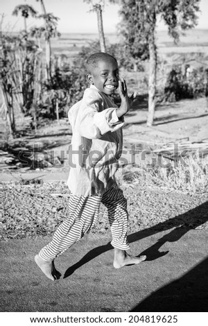 ANTANANARIVO, MADAGASCAR - JULY 3, 2011: Unidentified Madagascar boy runs happily smiling in the street. Children in Madagascar suffer of poverty due to slow development of the country