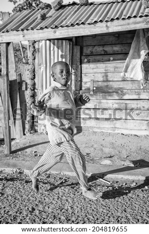 ANTANANARIVO, MADAGASCAR - JULY 3, 2011: Unidentified Madagascar boy runs happily in the street. People in Madagascar suffer of poverty due to slow development of the country