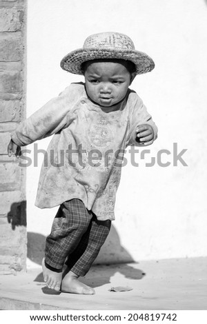 ANTANANARIVO, MADAGASCAR - JULY 1, 2011: Unidentified Madagascar boy runs in the street. People in Madagascar suffer of poverty due to slow development of the country