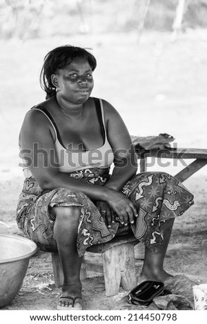 PORTO-NOVO, BENIN - MAR 8, 2012: Unidentified Beninese fat woman works at the market. People of Benin suffer of poverty due to the difficult economic situation.