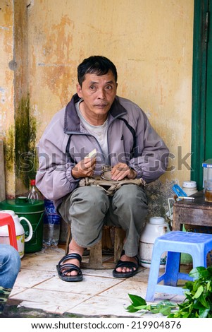 SAPA, VIETNAM - SEP 20, 2014: Unidentified Vietnamese man works at shop. Most of people of Vietnam belong to the Kinh (Viet) ethnic grop - 85.7%
