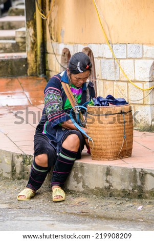 SAPA, VIETNAM - SEP 20, 2014: Unidentified Hmong woman in the Hmong traditional costume checks out her carriage. Hmong people is a minority ethnic group living in Sapa