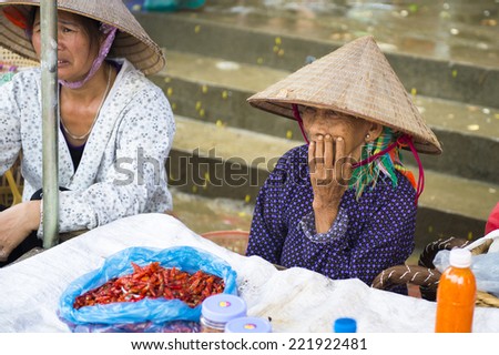 BAC HA, VIETNAM - SEP 21, 2014: Unidentified Vietnamese woman works at the Bac Ha Market, a large Sunday market with people wearing beautiful colored minorities costumes