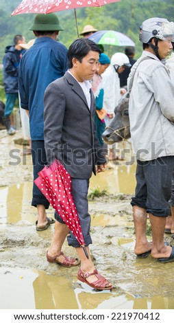BAC HA, VIETNAM - SEP 21, 2014: Unidentified man in a costume and slippers with umbrella at the Bac Ha Market, a large Sunday market with people wearing beautiful colored minorities costumes