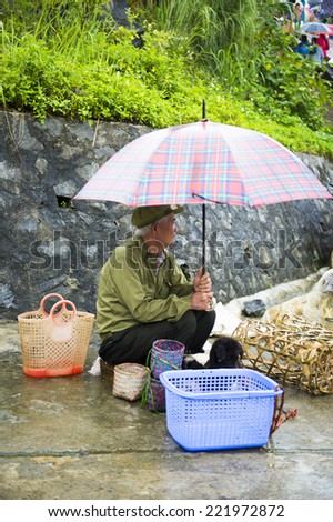 BAC HA, VIETNAM - SEP 21, 2014: Unidentified man sells at the Bac Ha Market, a large Sunday market with people wearing beautiful colored minorities costumes