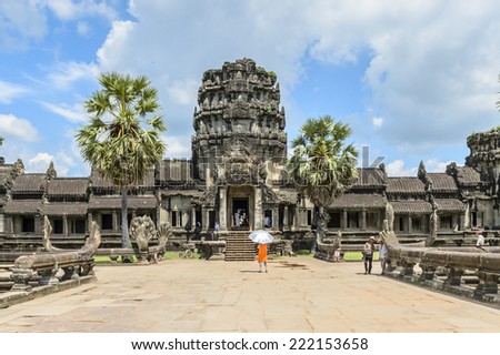 ANGKOR, SIEM REAP PROVINCE, CAMBODIA - SEP 27, 2014: Unidentified tourists walk on the territory of the Angkor Wat, the largest religious monument in the world, UNESCO World Heritage