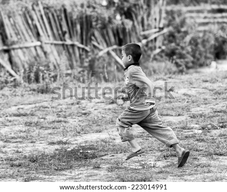 TA PHIN, VIETMAN - SEP 12, 2014: Unidentified Red Dao boy runs in the field in the village of Vietnam. Red Dao is a minority ethnic group of Vietnam