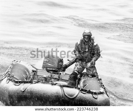 SOUTH GEORGIA, GREAT BRITAIN - NOV 9, 2012:  Unidentified man in a water proof suite in a rubber boat with a motor in the Atlantic Ocean. Atlantic Ocean is the world\'s second largest ocean