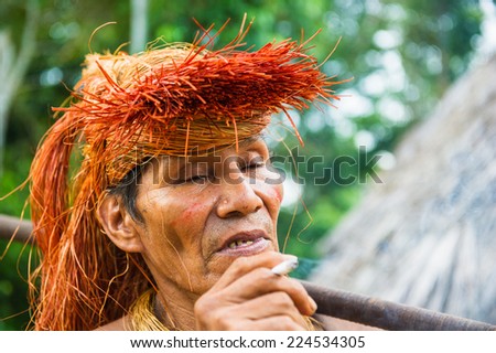 AMAZONIA, PERU - NOV 10, 2010: Unidentified Amazonian indigenous man smokes. Indigenous people of Amazonia are protected by COICA (Coordinator of Indigenous Organizations of the Amazon River Basin)