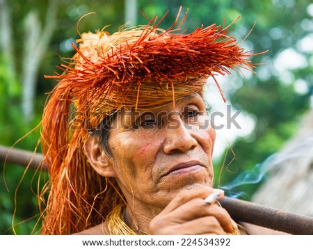 AMAZONIA, PERU - NOV 10, 2010: Unidentified Amazonian indigenous man smokes. Indigenous people of Amazonia are protected by COICA (Coordinator of Indigenous Organizations of the Amazon River Basin)