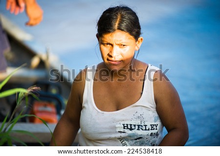 AMAZONIA, PERU - NOV 10, 2010: Unidentified Amazonian woman raws a wooden boat. Indigenous people of Amazonia are protected by COICA (Coordinator of Indigenous Organizations of the Amazon River Basin)