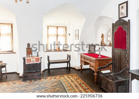 BRAN, ROMANIA - OCTOBER 27, 2013:  Table and the lamp in the Dracula Castle in Bran, Romania, on October 27, 2013. It is marketed as the home of the Vampire Dracula, the Bram Stoker\'s novel character.