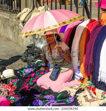 MEXICO CITY, MEXICO - DEC 29, 2011: Unidentified Mexican woman sells clothes in the street. 60% of Mexican people belong to the Mestizo ethnic group