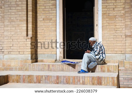 KHIVA, UZBEKISTAN - JUNE 4, 2011: Unidentified Uzbek man sits and thinks on a porch in Uzbekistan. 81% of people in Uzbekistan belong to Uzbek ethnic group