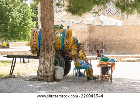 BUKHARA, UZBEKISTAN - JUNE 7, 2011: Unidentified Uzbek woman sell local drinks kvas and mors in the street in Uzbekistan, Jun 7, 2011.  81% of people in Uzbekistan belong to Uzbek ethnic group