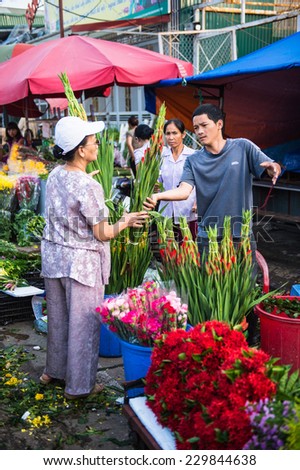 HANOI, VIETNAM - SEP 23. 2014: Unidentified woman works at the flower market in Hanoi, Vietnam. Flower market in Hanoi is one of the largest flower markets in Vietnam