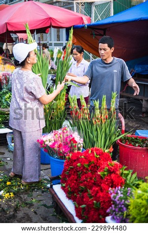 HANOI, VIETNAM - SEP 23. 2014: Unidentified woman works at the flower market in Hanoi, Vietnam. Flower market in Hanoi is one of the largest flower markets in Vietnam
