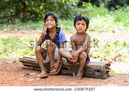 SIEM RIEP, CAMBODIA - SEP 28, 2014: Unidentified Khmer little boy and girl sit on a wood in Siem Reap. 90% of Cambodian people belong to Khmer etnic group