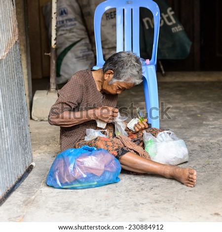 SIEM RIEP, CAMBODIA - SEP 28, 2014: Unidentified Khmer old woman counts money sitting on the ground in Siem Reap. 90% of Cambodian people belong to Khmer etnic group