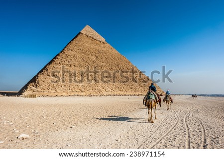GIZA, EGYPT - NOV 23, 2014: Unidentified Egyptian people on camels caravan near the Great Pyramid in  Giza Necropolis, Egypt. UNESCO World Heritage