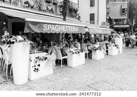 SIRMIONE, ITALY - JUNE 26, 2014: Street restaurant in the Sirmione town, Italy. Sirmione became popular touristic destination on the Lake garda, the largest lake in Italy