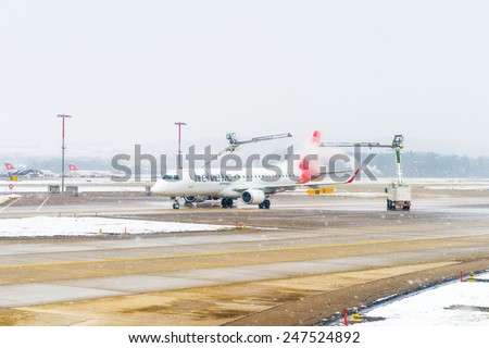 ZURICH, SWITZERLAND - JAN 26, 2015: Plane of the Swiss International Air Lines is treated by the anti freezing liquid in the Zurich Kloten Airport, the largest international airport of Switzerland