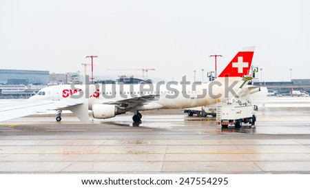 ZURICH, SWITZERLAND - JAN 26, 2015: Plane of the Swiss International Air Lines is treated by the anti freezing liquid in the Zurich Kloten Airport, the largest international airport of Switzerland