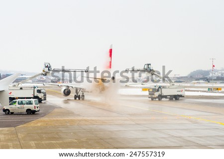 ZURICH, SWITZERLAND - JAN 26, 2015: Plane of the Swiss International Air Lines is treated by the anti freezing liquid in the Zurich Kloten Airport, the largest international airport of Switzerland