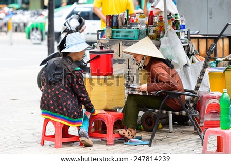 HO CHI MINH, VIETNAM - SEP 20, 2014: Unidentified Vietnamese women talk in the street. 90% of Vietnamese people belong to the Viet ethnic group