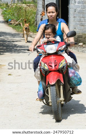 LAO CHAI VILLAGE, VIETNAM - SEP 22, 2014: Unidentified Hmong woman rides a motorbike in Lao Chai. Hmong is on of the minority eethnic group in Vietnam