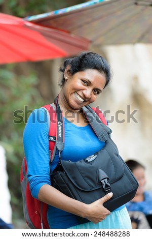LUANG PRABANG, LAOS - SEP 25, 2014: Unidentified Lao woman with a Canon camera bag. 55% of Laos people belong to the Lao ethnic group