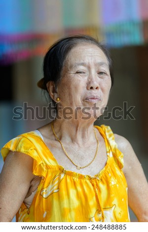 LUANG PRABANG, LAOS - SEP 25, 2014: Unidentified Lao woman in a yellow dress. 55% of Laos people belong to the Lao ethnic group