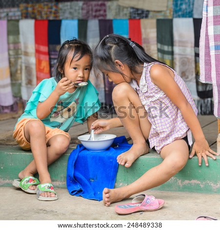 LUANG PRABANG, LAOS - SEP 25, 2014: Unidentified Lao little girls eat soup together. 55% of Laos people belong to the Lao ethnic group