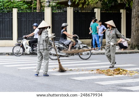 HANOI, VIETNAM - SEP 23, 2014: Unidentified Vietnamese woman cleans the street. 92% of Vietnamese people belong to the Viet ethnic group