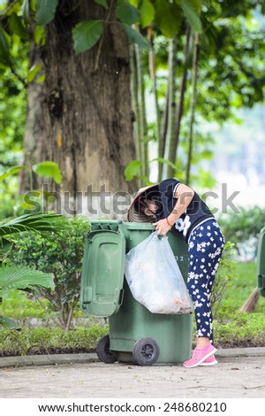 HANOI, VIETNAM - SEP 23, 2014: Unidentified Vietnamese woman checks a garbage. 92% of Vietnamese people belong to the Viet ethnic group