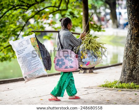 HANOI, VIETNAM - SEP 23, 2014: Unidentified Vietnamese woman carries a lot of stuff . 92% of Vietnamese people belong to the Viet ethnic group