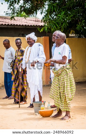LOME, TOGO - MAR 9, 2013: Unidentified Togolese men in traditional clothes prepares a local drink. People of Togo suffer of poverty due to the unstable economic situation.